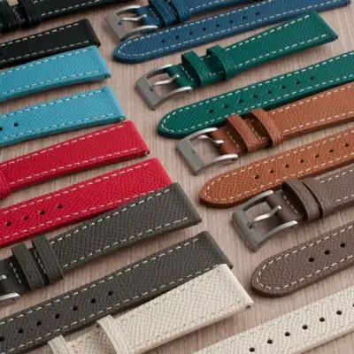 A variety of colorful watch straps in different materials and styles laid out on a wooden surface, showcasing options for travel adventures