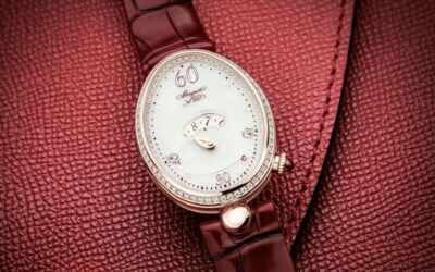 A close-up of an elegant watch with a white face and diamond accents, resting on a rich red leather background, perfect for a romantic date night accessory
