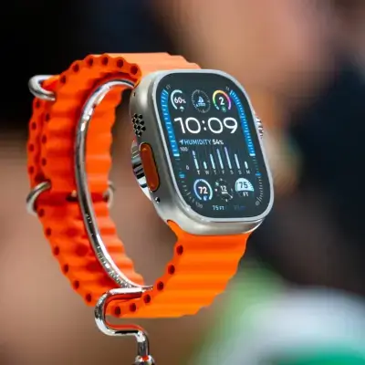 A close-up of a smartwatch with a vibrant orange tech-focused strap, showcasing its sleek design and advanced features on the display