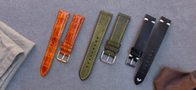 A selection of leather watch straps in various colors and styles, displayed on a textured surface, ideal for enhancing any watch for different occasions