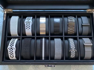 A collection of various metal watch bands displayed in a sleek storage box, showcasing different styles and colors for selecting the perfect accessory