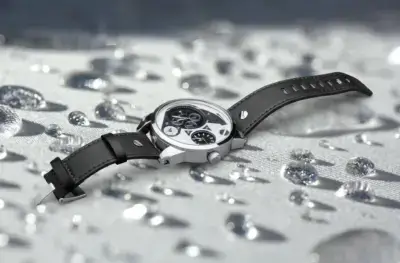 A close-up of a waterproof watch with a black strap, resting on a surface with water droplets, illustrating the importance of proper strap maintenance