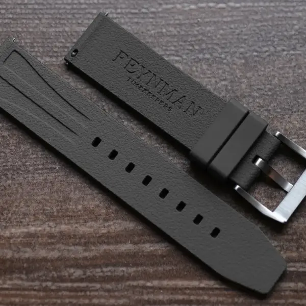 A close-up view of a black FKM rubber smartwatch strap with a silver buckle, showcasing its sleek design and durability, ideal for everyday wear