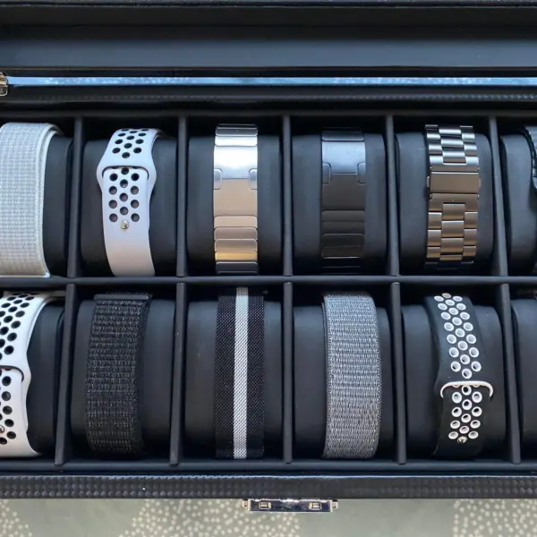 A collection of various metal watch bands displayed in a sleek storage box, showcasing different styles and colors for selecting the perfect accessory