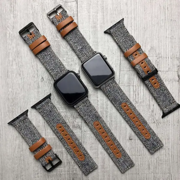 A variety of smartwatch straps designed for active lifestyles, featuring a mix of herringbone fabric and leather accents, arranged on a wooden surface