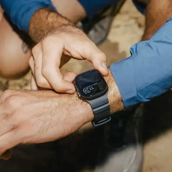 A person adjusts a fitness watch on their wrist while outdoors, showcasing a focus on selecting the ideal strap for an active lifestyle