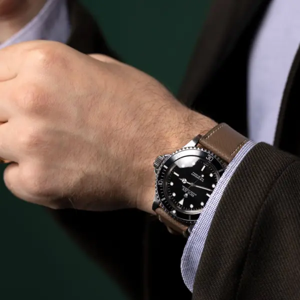 A close-up of a man's wrist wearing a stylish watch with a brown leather band, showcasing a professional look suitable for a job interview