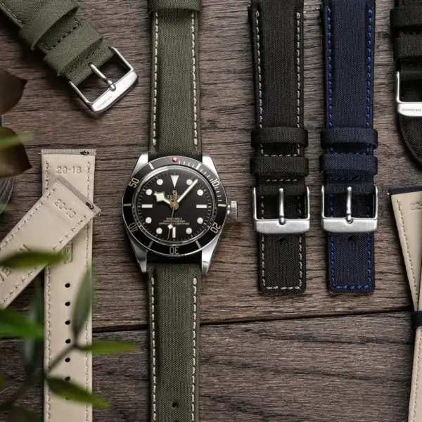 A stylish smartwatch surrounded by various watch straps in different colors and materials, set against a wooden background with greenery