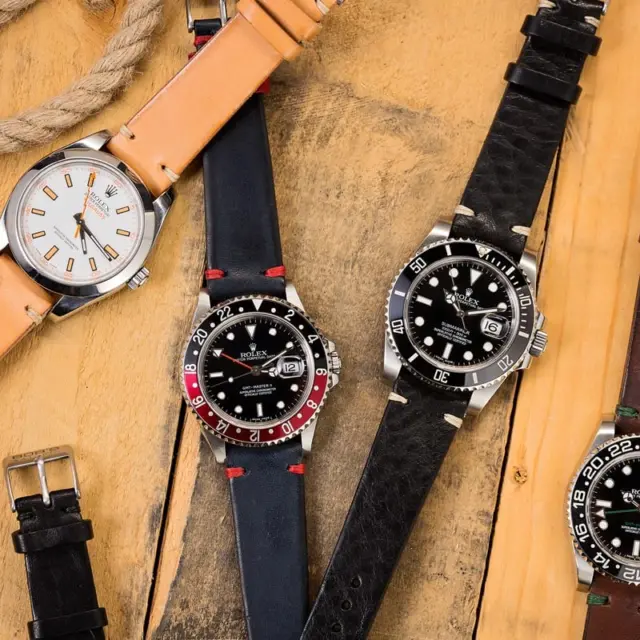 A collection of wristwatches featuring various leather straps displayed on a wooden surface, highlighting the historical significance and craftsmanship of leather in watchmaking